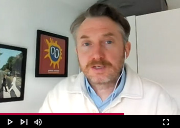 Video frame of a person speaking, displayed on a video player interface.